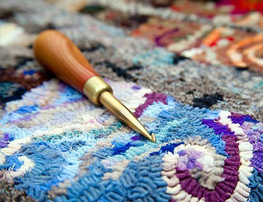 blue and purple hooked rug with tool